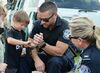 Border Patrol Agent Jared Hahn shows a child how handcuffs work during the National Night Out community event held at Timber Mill Park in Baudette, Minn., on Aug. 2, 2022.