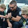 Border Patrol Agent Jared Hahn shows a child how handcuffs work during the National Night Out community event held at Timber Mill Park in Baudette, Minn., on Aug. 2, 2022.