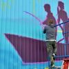 Artist Jonathan Judge, the director of media and campaigns for Rise Above Colorado, puts the finishing touches on a new mural on the south side of Ronning’s in downtown Baudette on Monday, May 23, 2022.